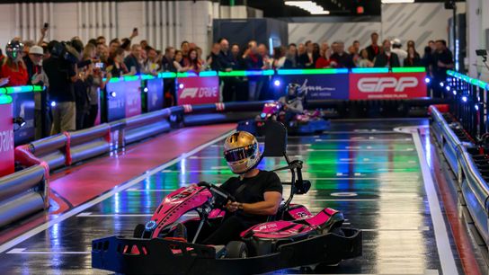 2009 Formula 1 World Champion Jenson Button, slides his kart to the side as he crosses the finish line in first place in the Ceremonial First Race, during a preview event at the Formula 1 experience at Grand Prix Plaza, the home to the Las Vegas Grand Prix, in Las Vegas, Nevada, Friday, March. 28, 2025. 